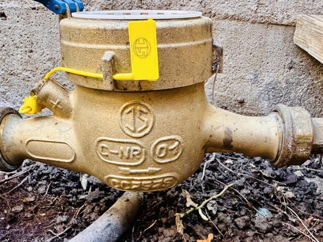 Wasserzähler im Garten mit gelber Plombe