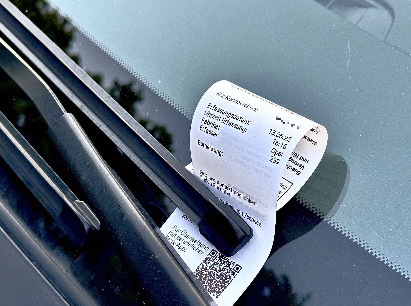 Verwarngeld wegen fehlendem oder ungültigem Parkausweis Ein Verwarngeldzettel unter dem Scheibenwischer eines Autos in der Kleingartenanlage