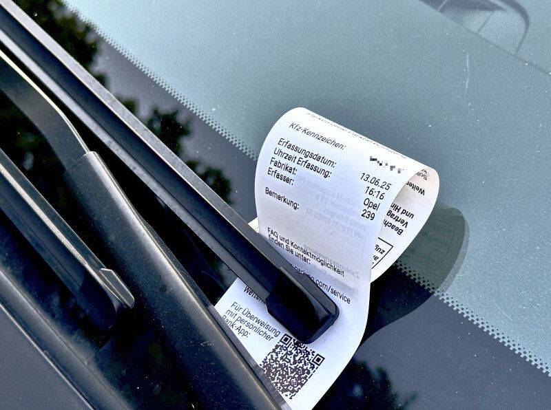 Ein Verwarngeldzettel unter dem Scheibenwischer eines Autos in der Kleingartenanlage