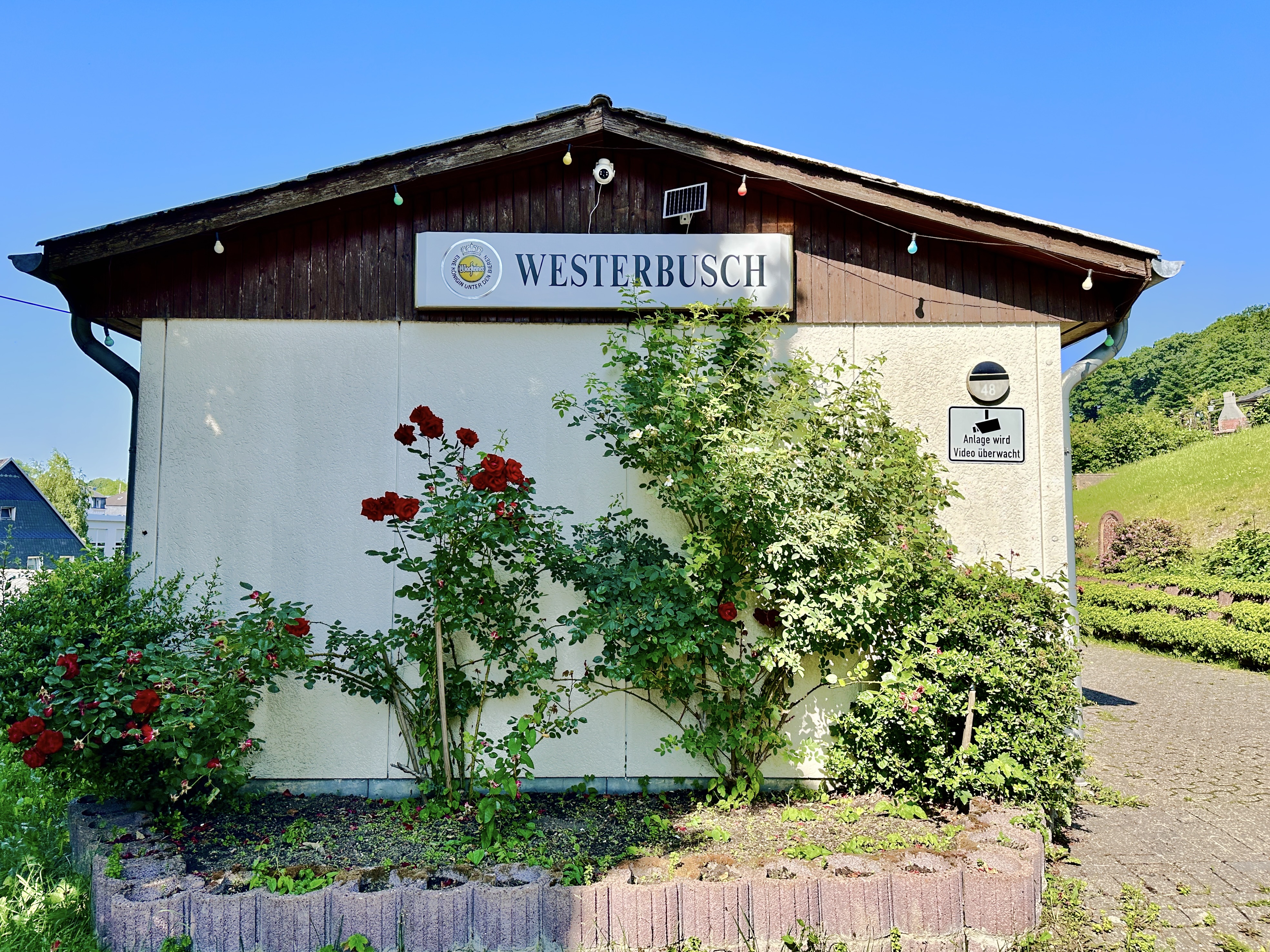 Vereinsheim des KGV Westerbusch Vereinsheim des KGV Westerbusch mit Westerbusch-Schild und bepflanztem Eingangsbereich