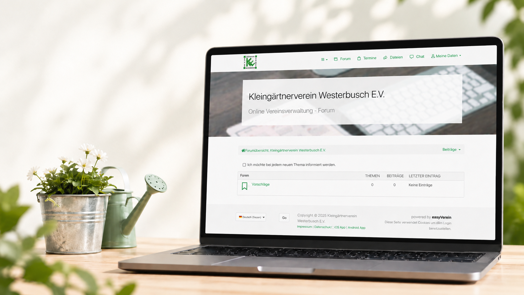 Mitgliederportal des KGV Westerbusch Laptop mit geöffnetem Mitgliederportal des KGV Westerbusch neben Blumen und Gießkanne